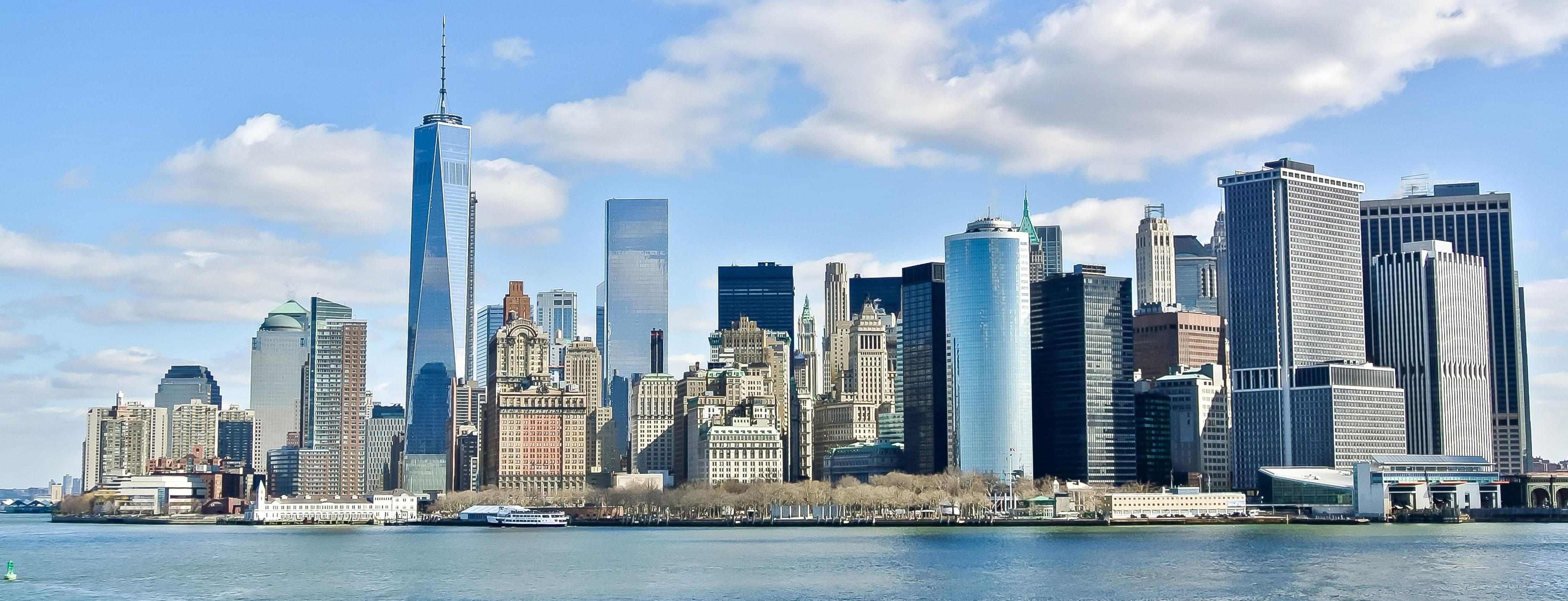 The New York City skyline on a beautiful day, with the One World Trade Center building in the middle.